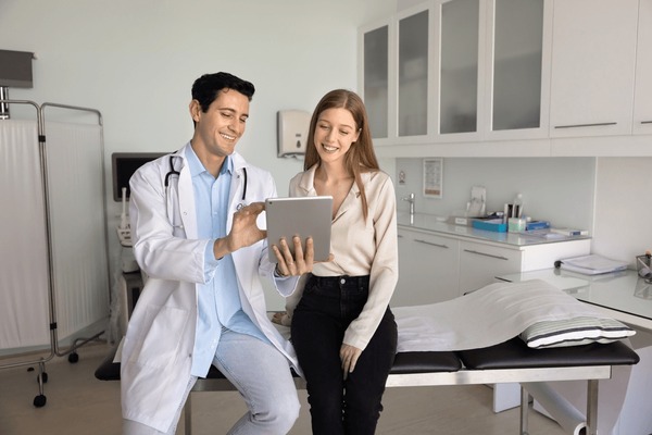Médico usando tablet com paciente